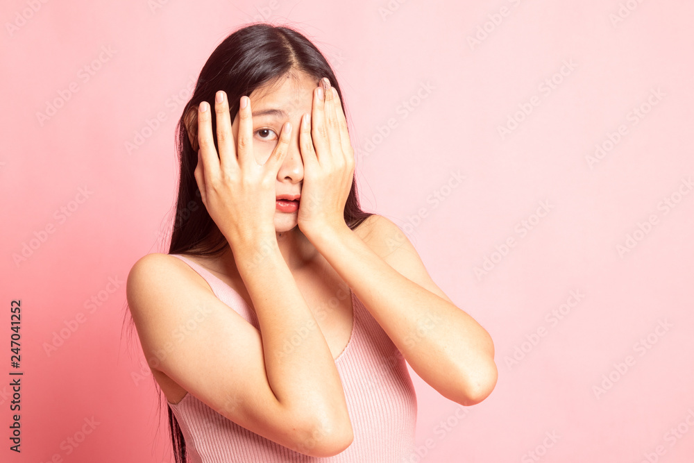Beautiful young Asian woman peeking through fingers. Beautiful young Asian woman peeking through fingers.