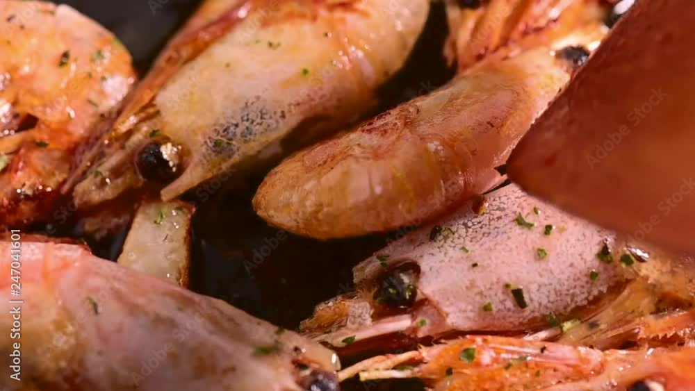 Cooking fried Shrimps with herbs and garlic close-up Cooking fried Shrimps with herbs and garlic close-up