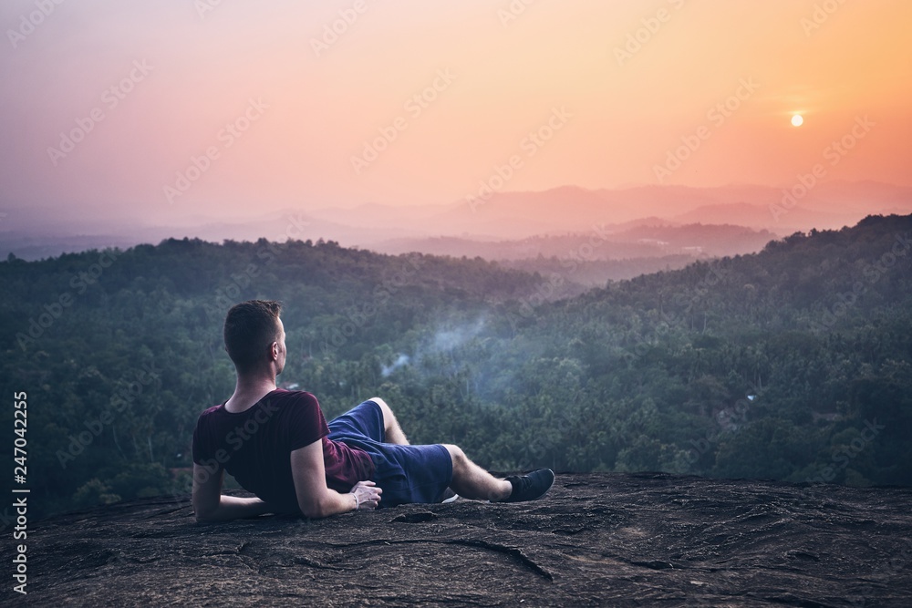 Man contemplation on top of rock