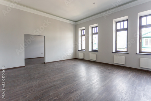 Side view of unfurnished room loft interior with wooden floor, white walls with bright daylight