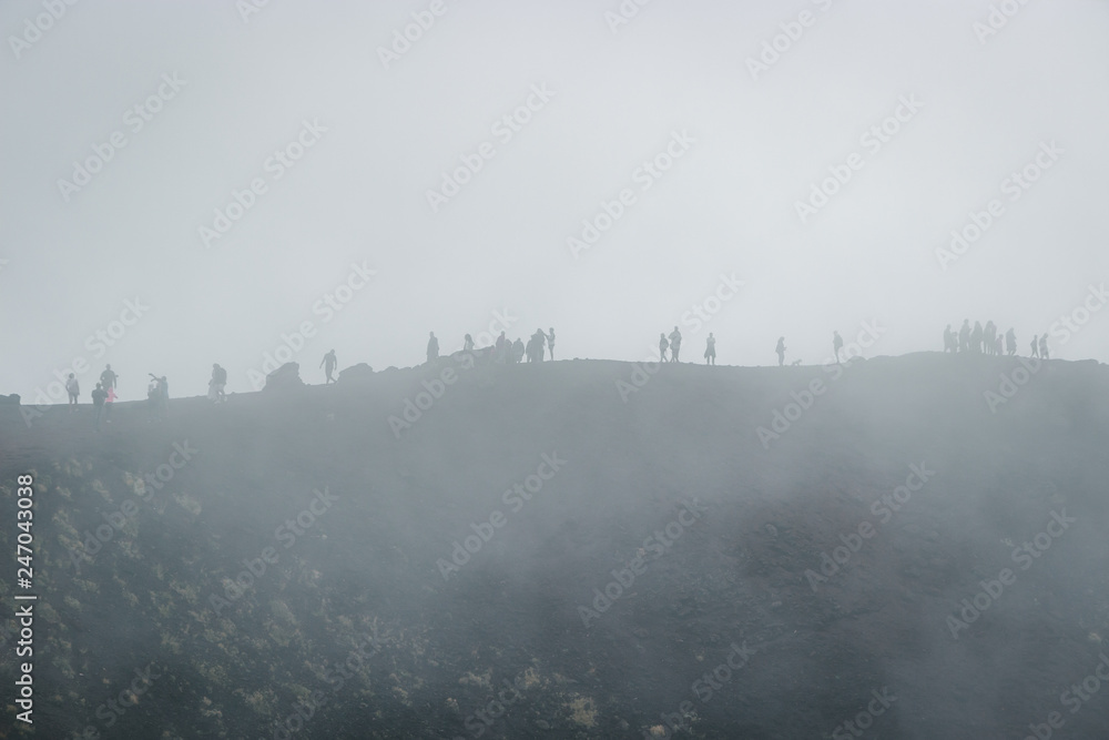 Excursion in the Silvestri crater, Volcano Etna and people in the fogh