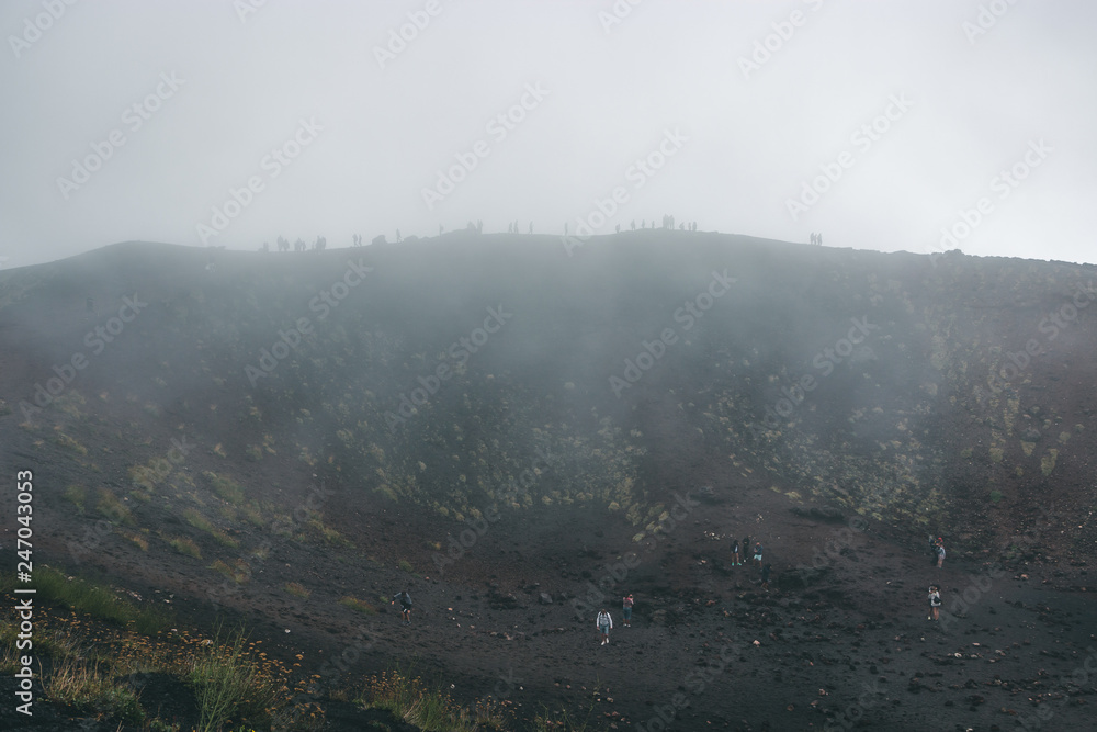 Excursion in the Silvestri crater, Volcano Etna and people in the fogh