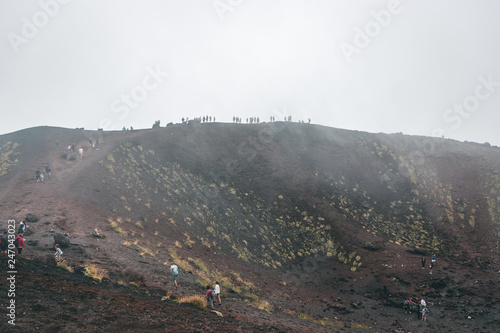 Excursion in the Silvestri crater, Volcano Etna and people in the fogh photo