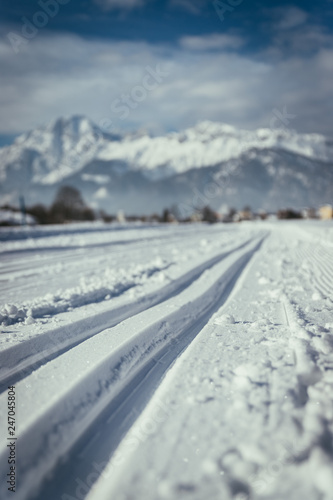 Cross-country skiing in Austria: Slope, fresh white powder snow and mountains, blurry background