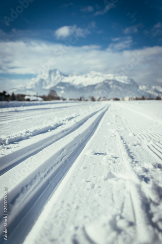 Cross-country skiing in Austria: Slope, fresh white powder snow and mountains, blurry background © Patrick Daxenbichler