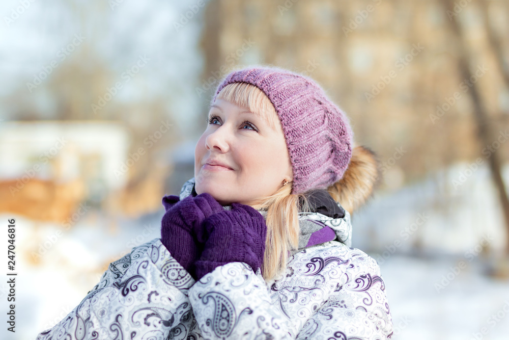 Beautiful dreaming blond young woman in a knitted hat looking up Beautiful dreaming blond young woman in a knitted hat looking up