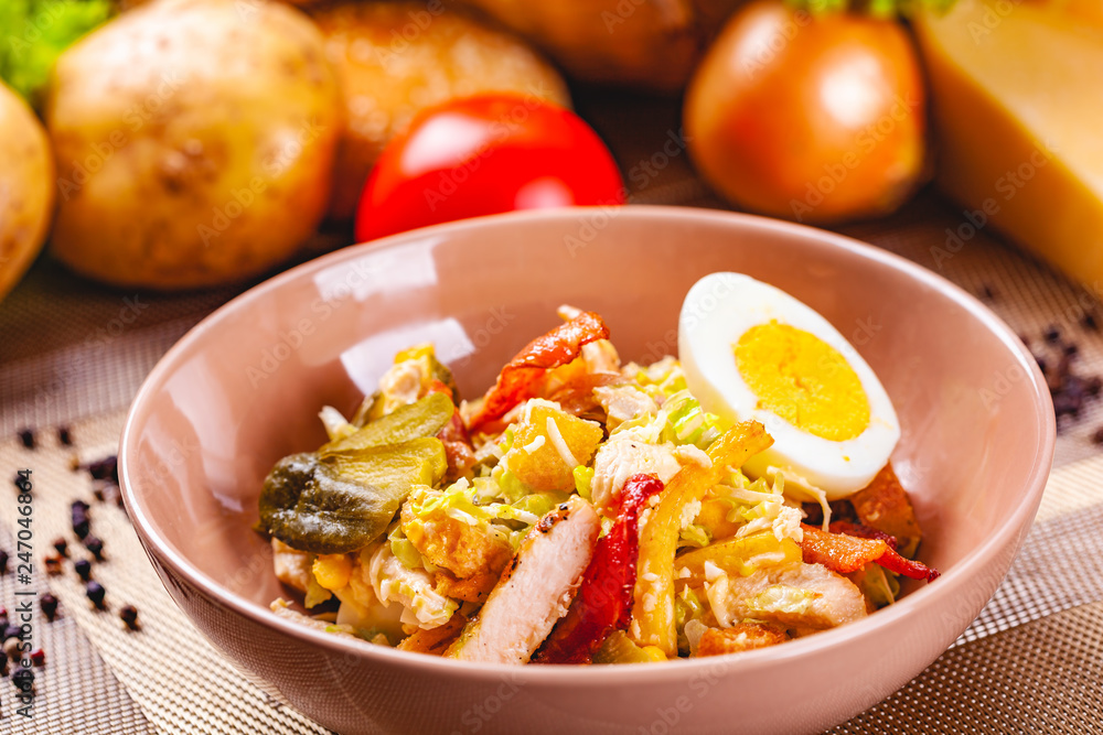 Potato salad with chicken and bacon in beige bowl Potato salad with chicken and bacon in beige bowl
