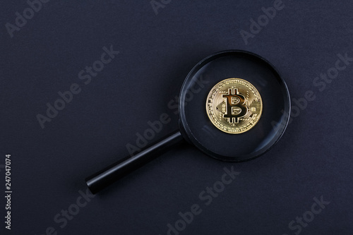 coin bitcoin under a magnifying glass