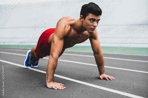 Orderly stripped to waist man doing push-ups