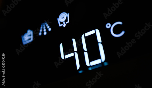Washing machine panel display, setting 40 degrees temperature. Abstract laundry programming.