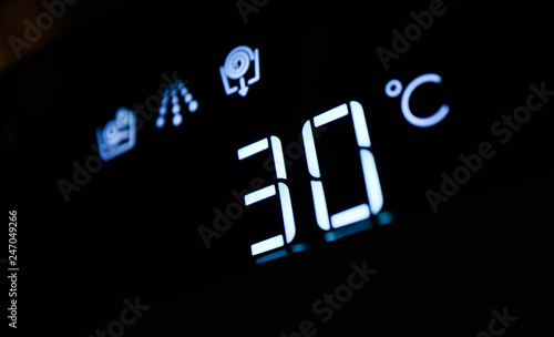 Washing machine panel display, setting 30 degrees temperature. Abstract cold water laundry programming backdrop, closeup. photo