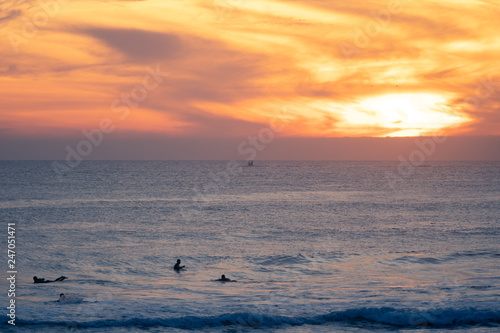 Carcavelos beach filled with many surfers at Sunset, Lisbon, Portugal