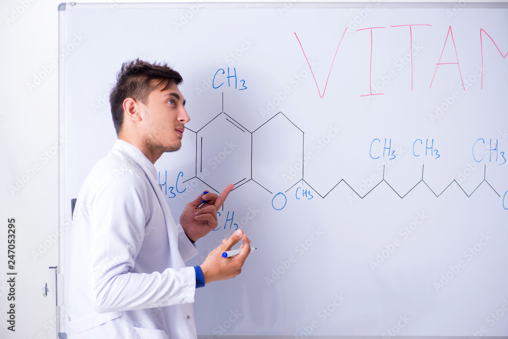 Young chemist standing in front of the whiteboard Young chemist standing in front of the whiteboard