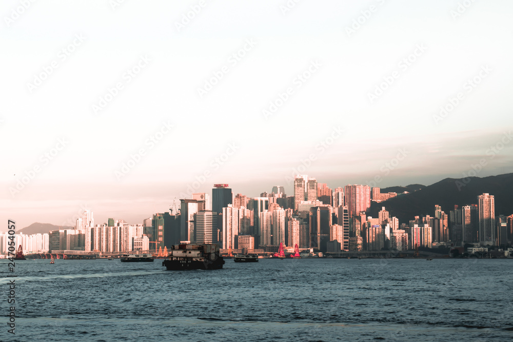 Cargo ships crossing the Victoria Harbor in Hong Kong China during sunset