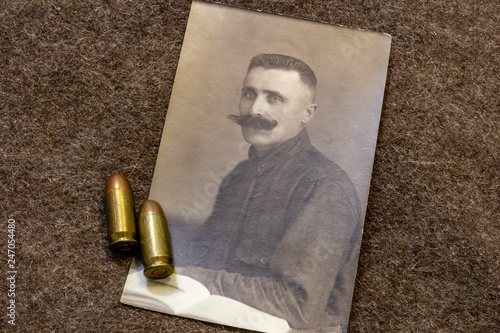 Naklejka Portrait of officer in period of World War I and pistol bullets on trench coat
