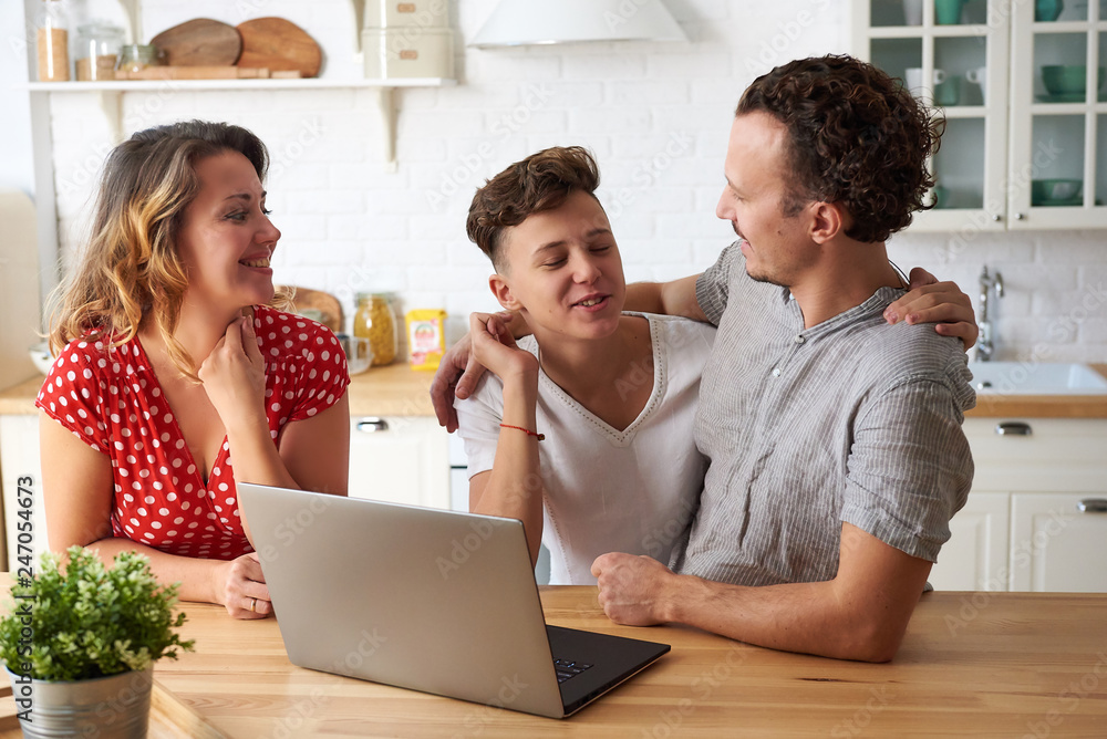 happy family with laptop at kitchen. Son, mother and father together. happy family with laptop at kitchen. Son, mother and father together.