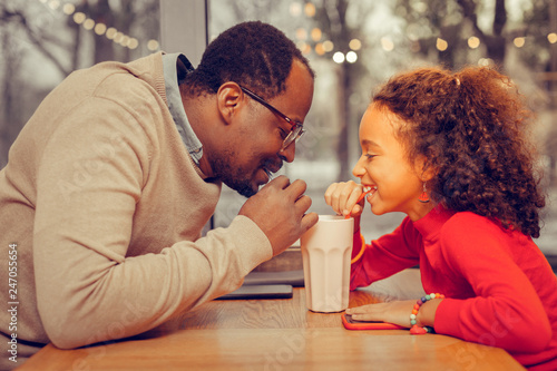 Father and daughter drinking milk cocktail together