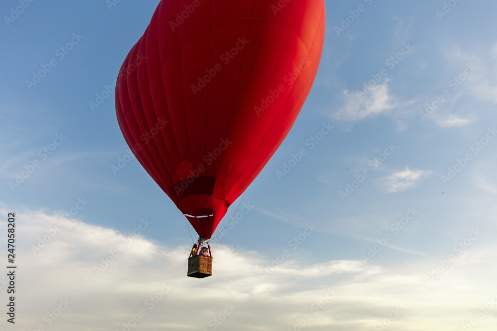 Fototapeta premium Valentine's Day. Red hot air balloon in the shape of a heart fly in sky. Love, honeymoon and romantic travel concept
