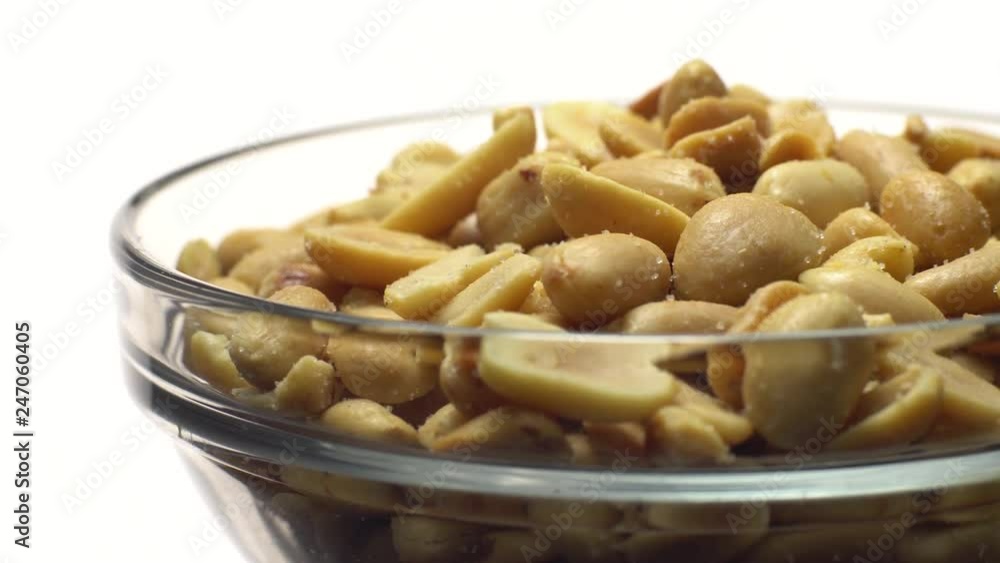 Peanuts. Peeled peanuts fried with salt. Rotation. Snack closeup. Peanuts in a bowl. Selective focus. Isolated on white. Studio shot. Peanuts. Peeled peanuts fried with salt. Rotation. Snack closeup. Peanuts in a bowl. Selective focus. Isolated on white. Studio shot.