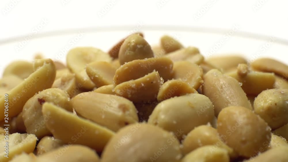 Peanuts. Peeled peanuts fried with salt. Rotation. Snack closeup. Peanuts in a bowl. Selective focus. Isolated on white. Studio shot. Peanuts. Peeled peanuts fried with salt. Rotation. Snack closeup. Peanuts in a bowl. Selective focus. Isolated on white. Studio shot.