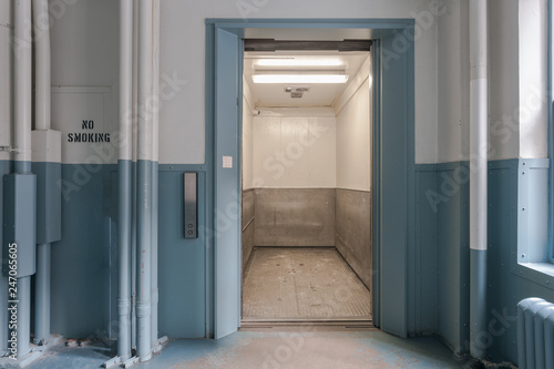 Open freight elevator in blue and white bay of office building