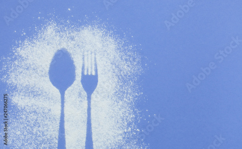  Can use as mockup for design.Top view of cutlery silhouette made with flour and powdered sugar on a bright purple paper background with space for text. Culinary art, flat lay photo