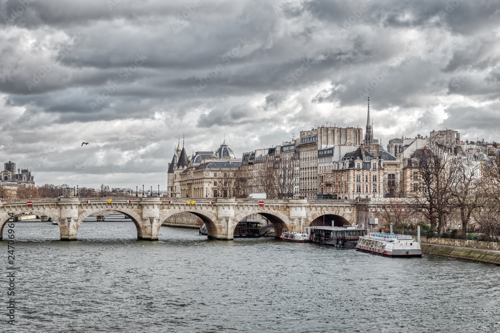 Fototapeta premium Panorama of Ile de la Cite, the Conciergerie and Pont Neuf on a cloudy day in winter - Paris, France