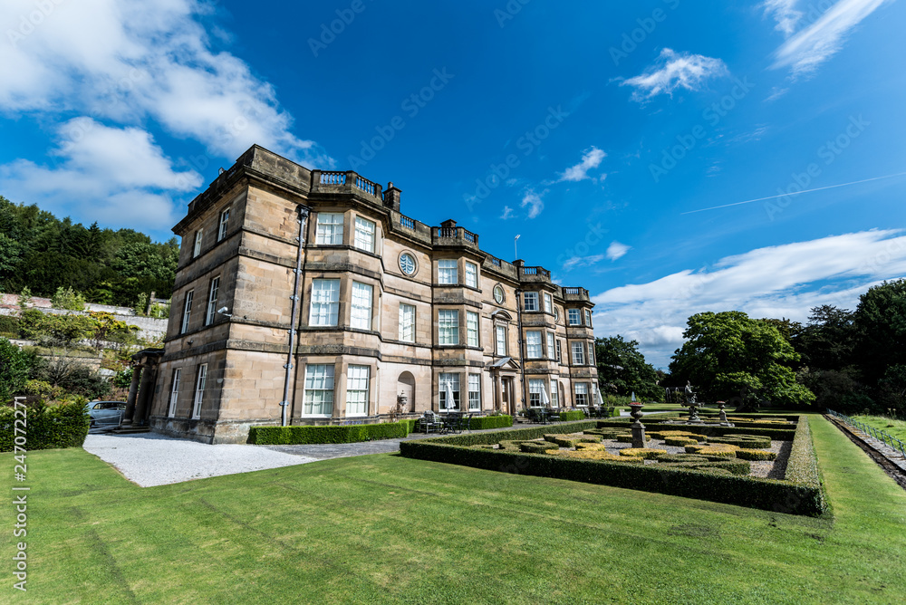 English stately home in summer surrounding by gardens