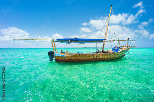 alone wooden boat on emerald sea of Indian ocean in Zanzibar in Tanzania