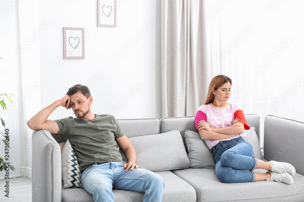 Couple ignoring each other after argument in living room. Relationship problems