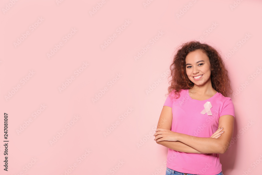 African-American woman with silk ribbon and space for text on color background. Breast cancer awareness concept African-American woman with silk ribbon and space for text on color background. Breast cancer awareness concept