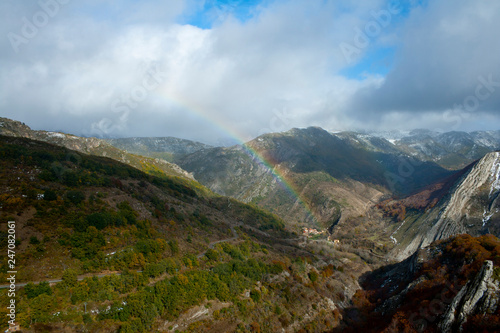 Rainbow in a mountainous landscape with beech forests.