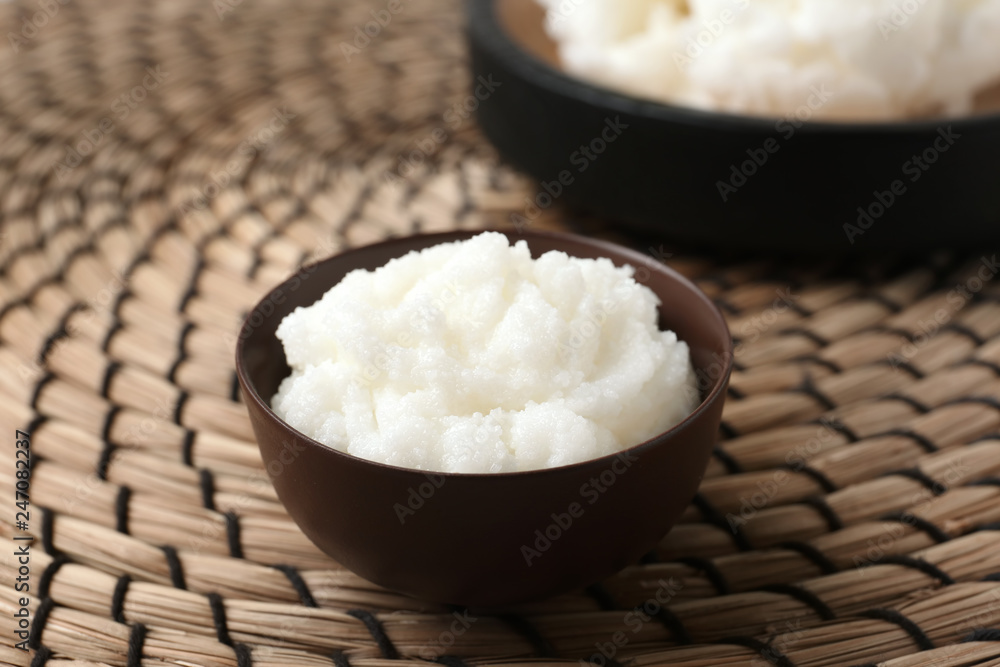 Shea butter in bowl on wicker mat, closeup Shea butter in bowl on wicker mat, closeup