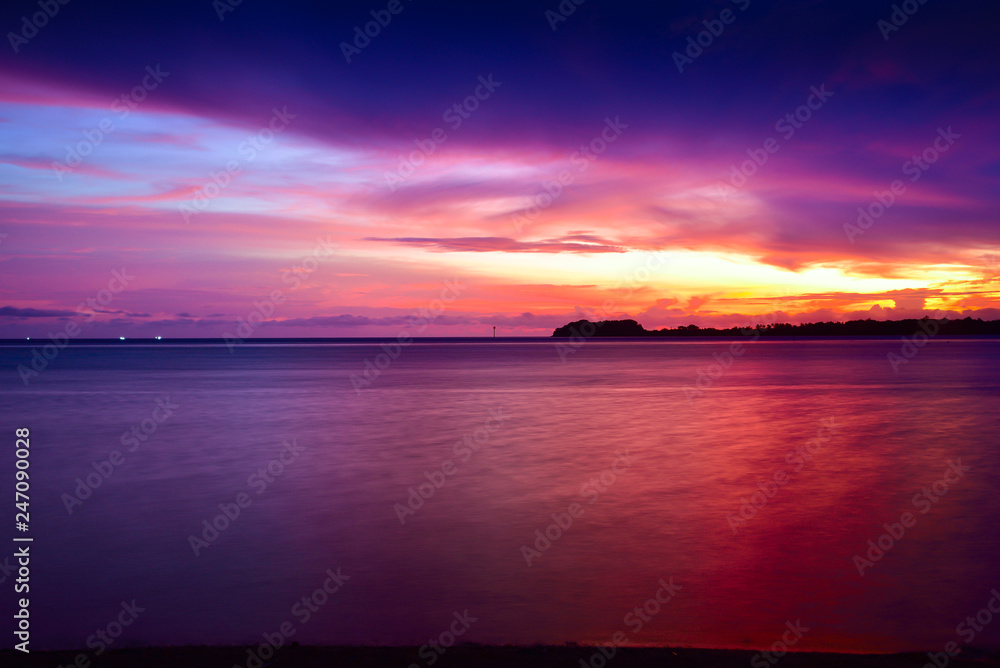 Sunset at a pacific tropical beach with calm peaceful ocean wave with sandy beach in the family couple resort Sunset at a pacific tropical beach with calm peaceful ocean wave with sandy beach in the family couple resort