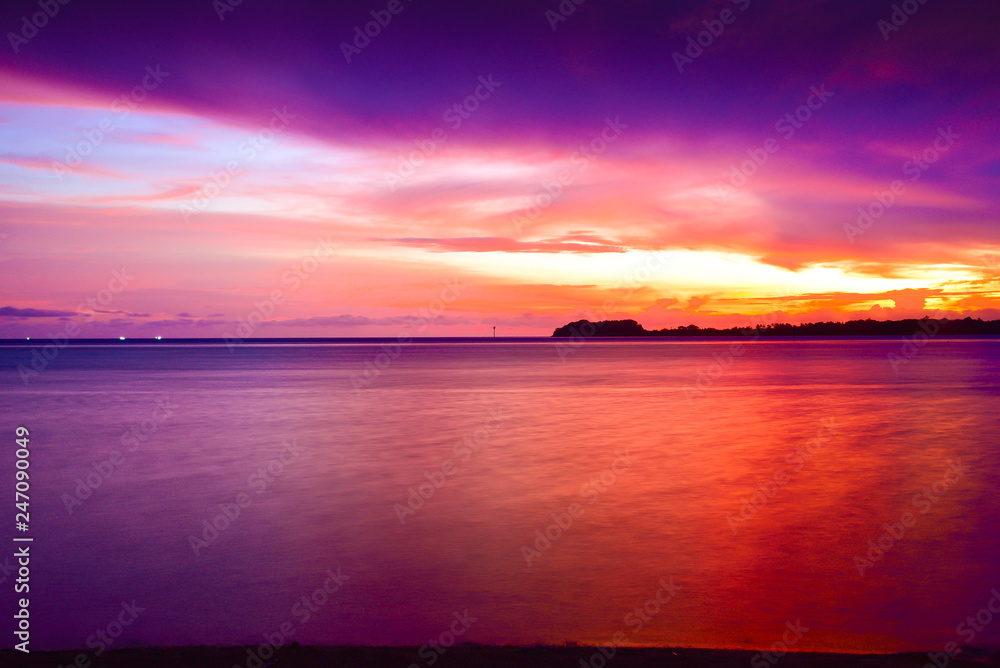 Sunset at a pacific tropical beach with calm peaceful ocean wave with sandy beach in the family couple resort
