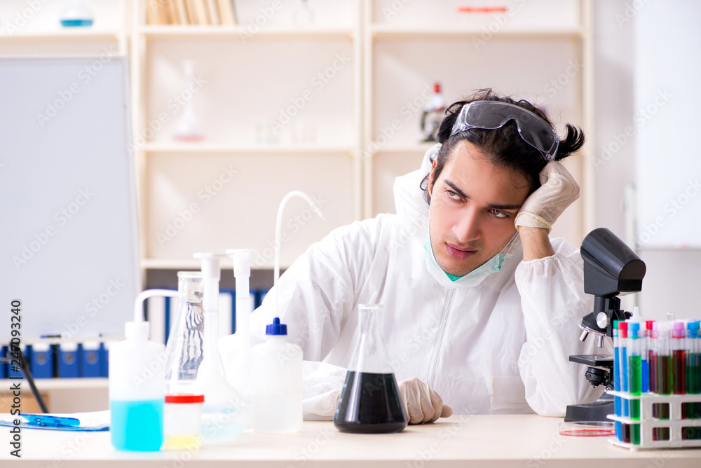 Young handsome chemist working in the lab Young handsome chemist working in the lab