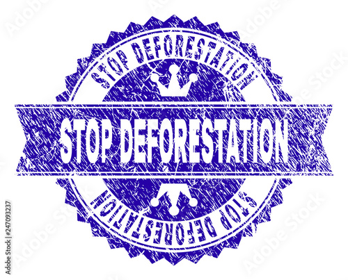 STOP DEFORESTATION rosette seal overlay with distress texture. Designed with round rosette, ribbon and small crowns. Blue vector rubber print of STOP DEFORESTATION text with dust texture.