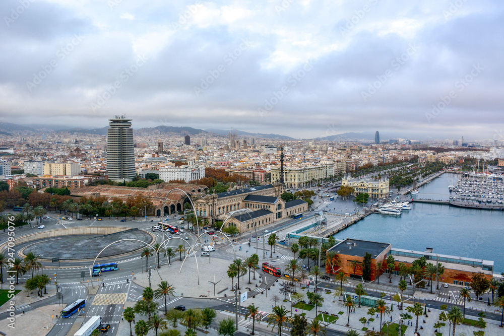 Aerial view over historical city center of Barcelona Spain with La Rambla main street, square Portal de la pau, Port Vell marina and Columbus Monument after sunset.