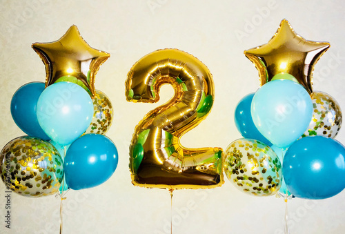 Composition of helium balloons of soft blue, blue and gold, stars and a big number 2
