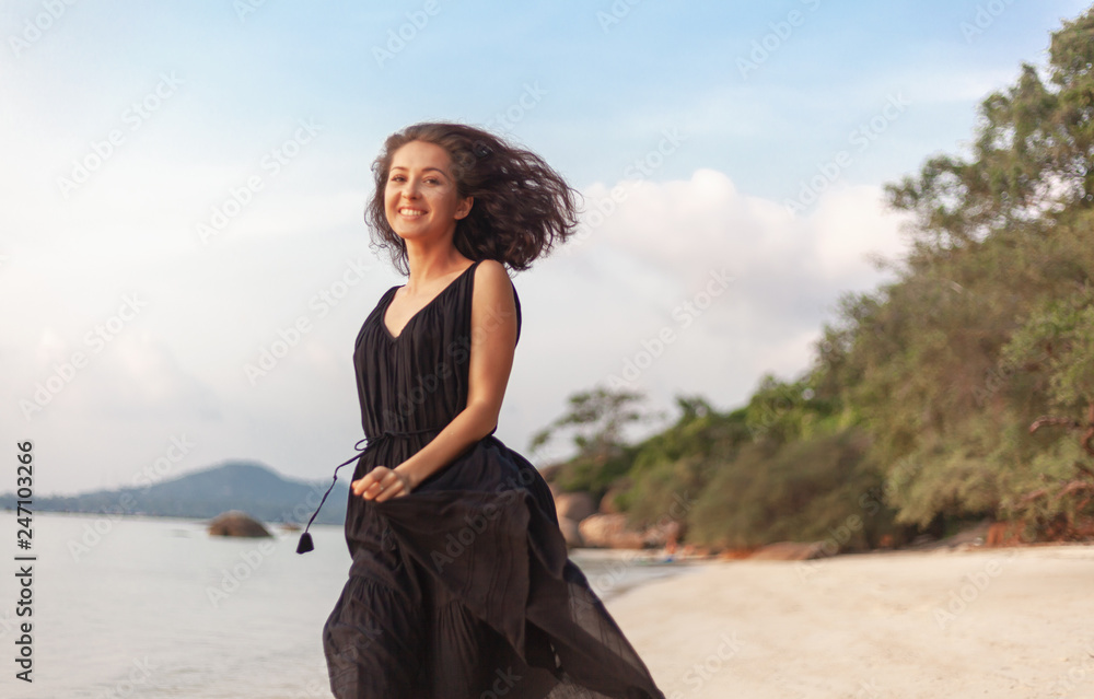 Young beautiful happy sensual woman in a stylish dress joyfully runs along the beach, beauty and fashion, leisure and travel concept Young beautiful happy sensual woman in a stylish dress joyfully runs along the beach, beauty and fashion, leisure and travel concept