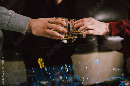 View from the top. Hands of people with glasses of whiskey or wine  celebrating and toasting of the wedding  meeting or other celebration