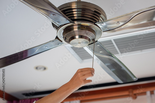 Fototapeta electric irony ceiling fan and woman hand