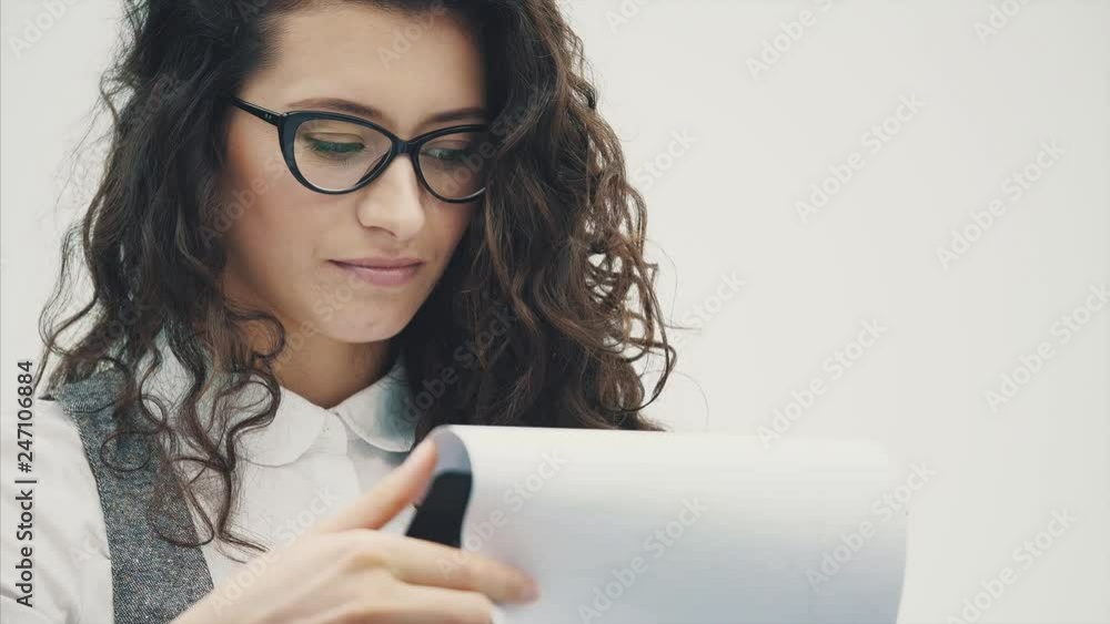 Young energetic girl in glasses stands on a white background. Young energetic girl in glasses stands on a white background.