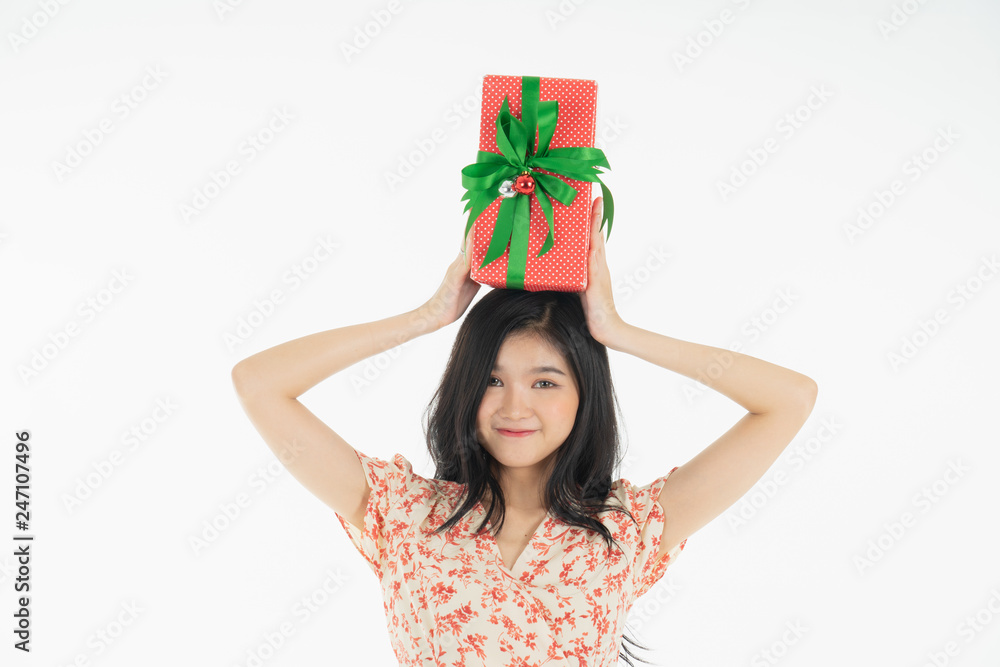 Young woman holding gift box with red bow being excited and surprised holiday present isolated white background Young woman holding gift box with red bow being excited and surprised holiday present isolated white background