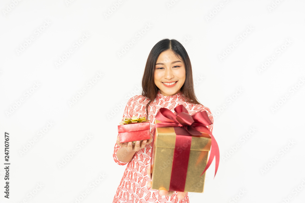 Photo of asian curious woman in red dress rejoicing her birthday or new year gift box. Young woman holding gift box with red bow being excited and surprised holiday present isolated white background Photo of asian curious woman in red dress rejoicing her birthday or new year gift box. Young woman holding gift box with red bow being excited and surprised holiday present isolated white background