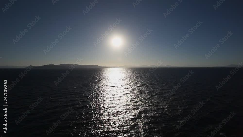View of the horizon with the sun setting on the coast of the Greek islands View of the horizon with the sun setting on the coast of the Greek islands