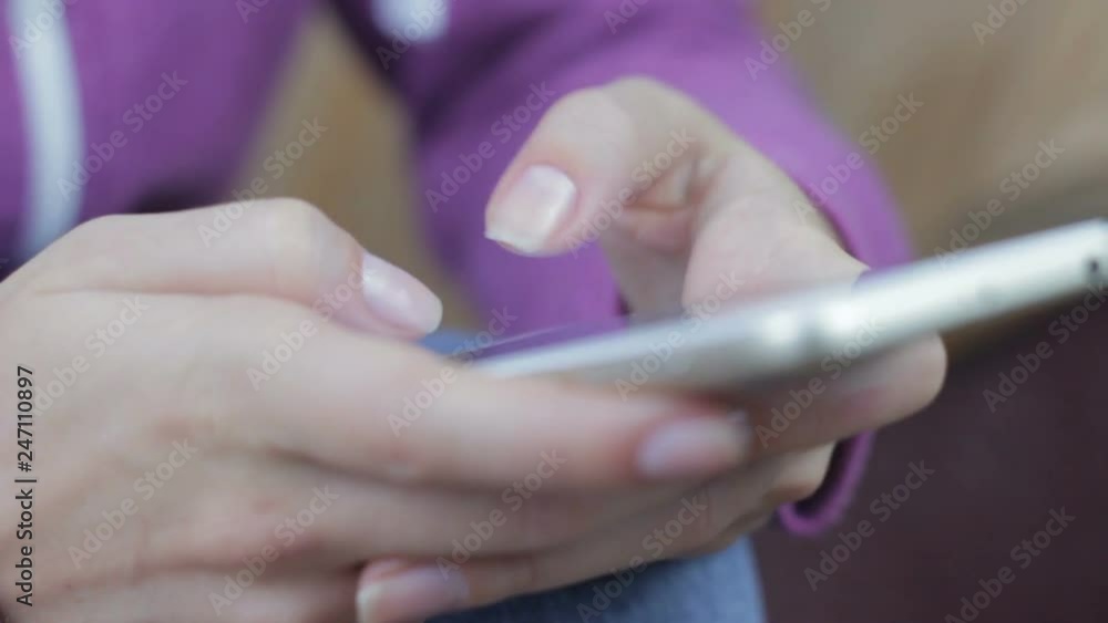 Woman hand typing mobile message on screen smartphone. Close up female hands holding smartphone and browsing website Woman hand typing mobile message on screen smartphone. Close up female hands holding smartphone and browsing website