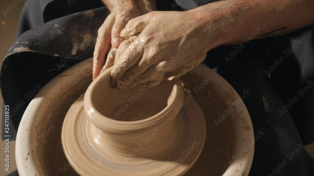 Two intertwined hands form a pot of clay on a potter's wheel. A male hand helps a woman's hands shape a clay shape. Two intertwined hands form a pot of clay on a potter's wheel. A male hand helps a woman's hands shape a clay shape.