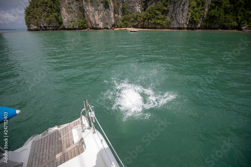 The photo was made on the islands Phi - Phi in the province of Krabi, in Thailand. The photo shows us a splashes on the water, the rocks of the water area and the boat in the distance.
