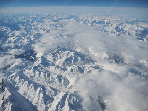 Aerial landscape of the Alps in Europe during winter season with fresh snow. View from the window of the airplane